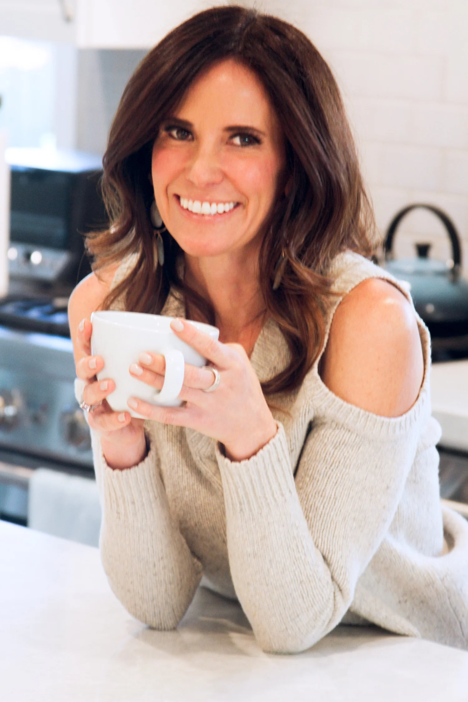 Elizabeth Greenfield holding a mug in her kitchen — functional medicine practitioner